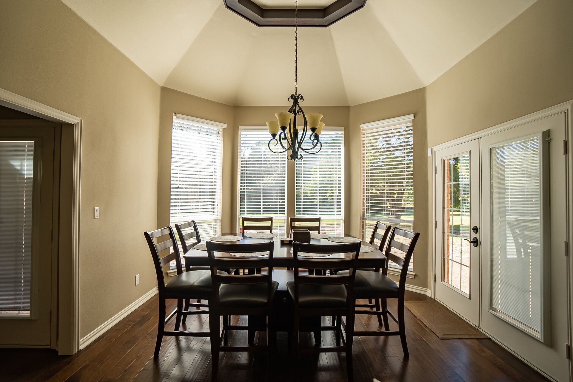 A dining room with a table and chairs and a chandelier