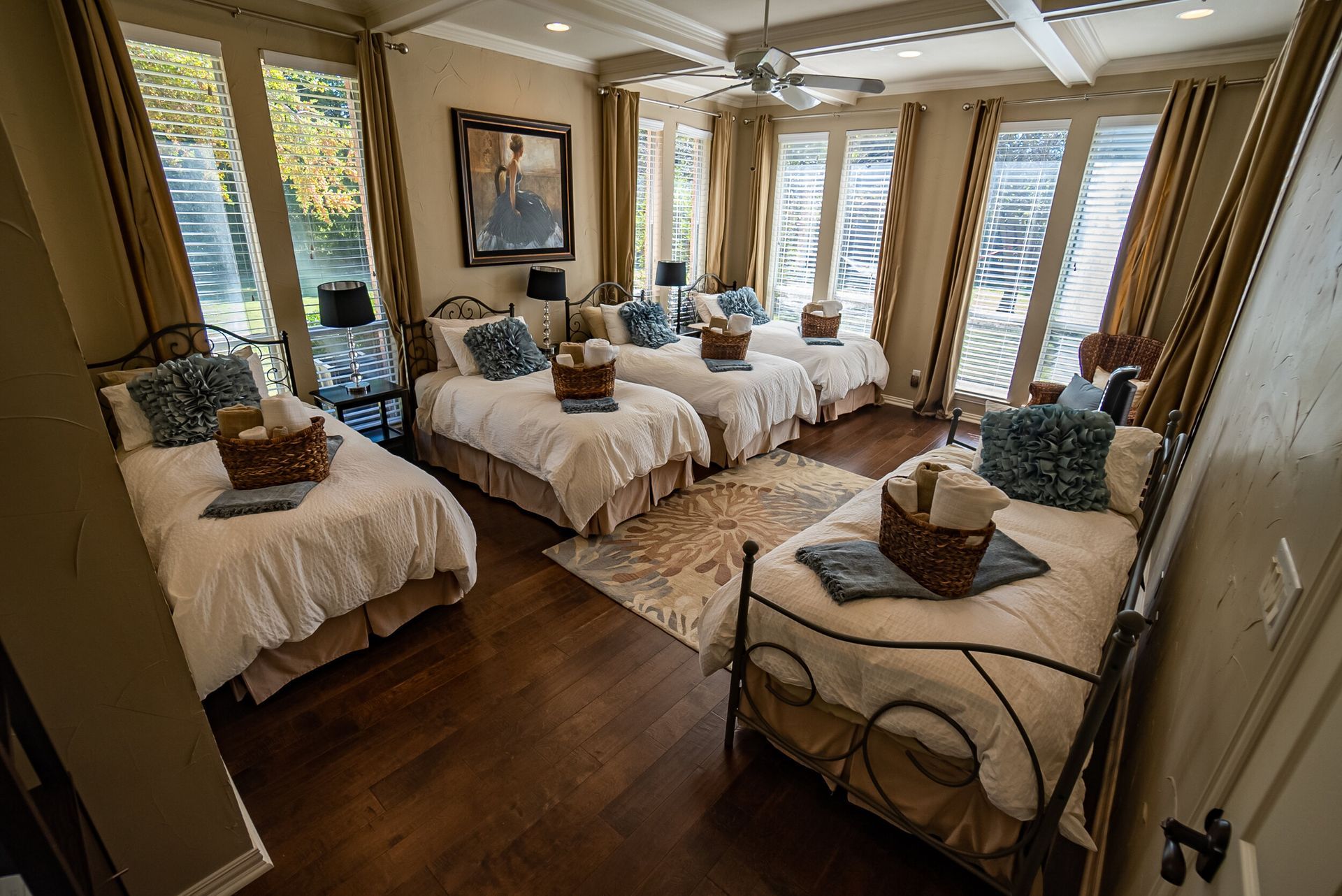 A bedroom with four beds and a ceiling fan.