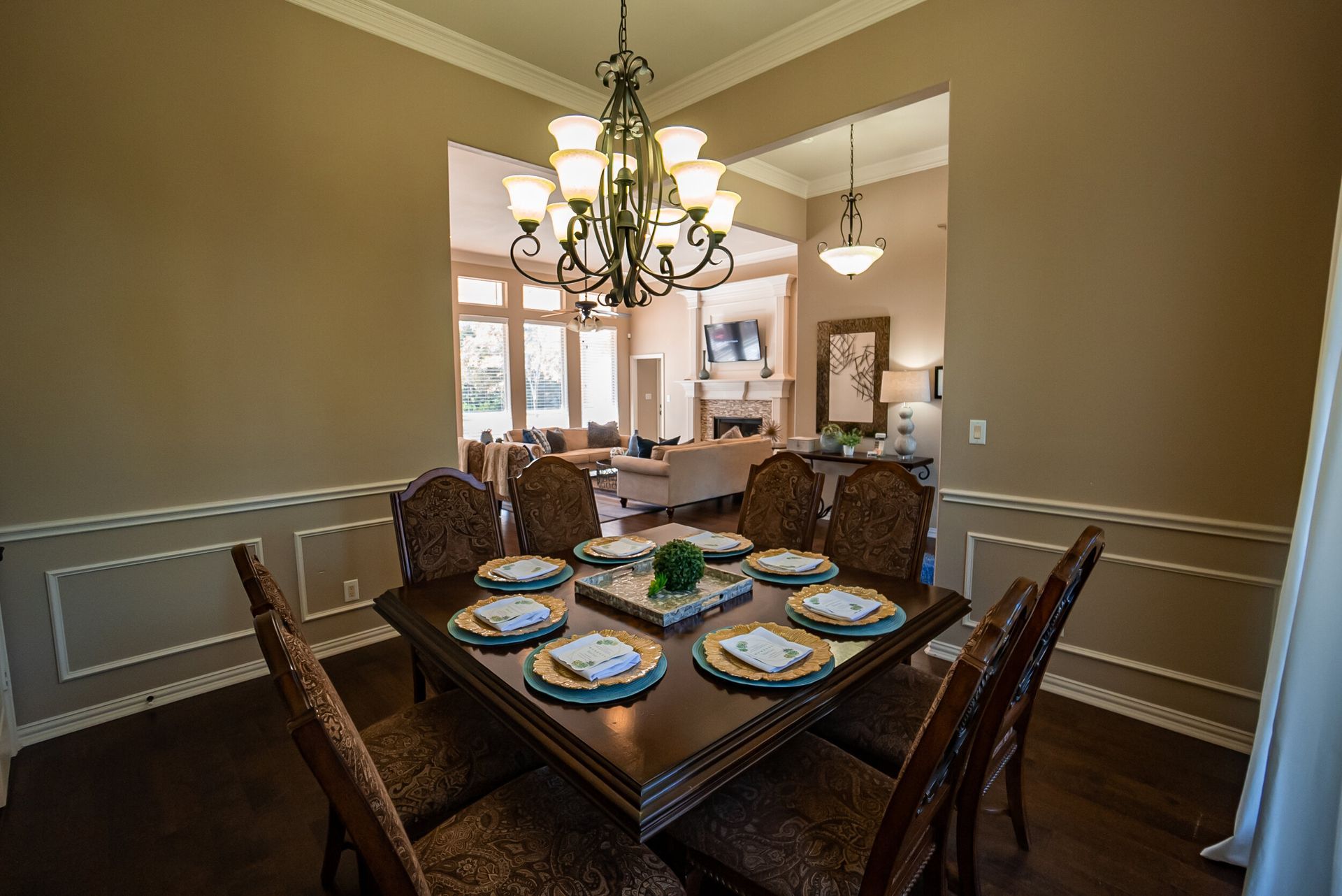 A dining room with a table and chairs and a chandelier.