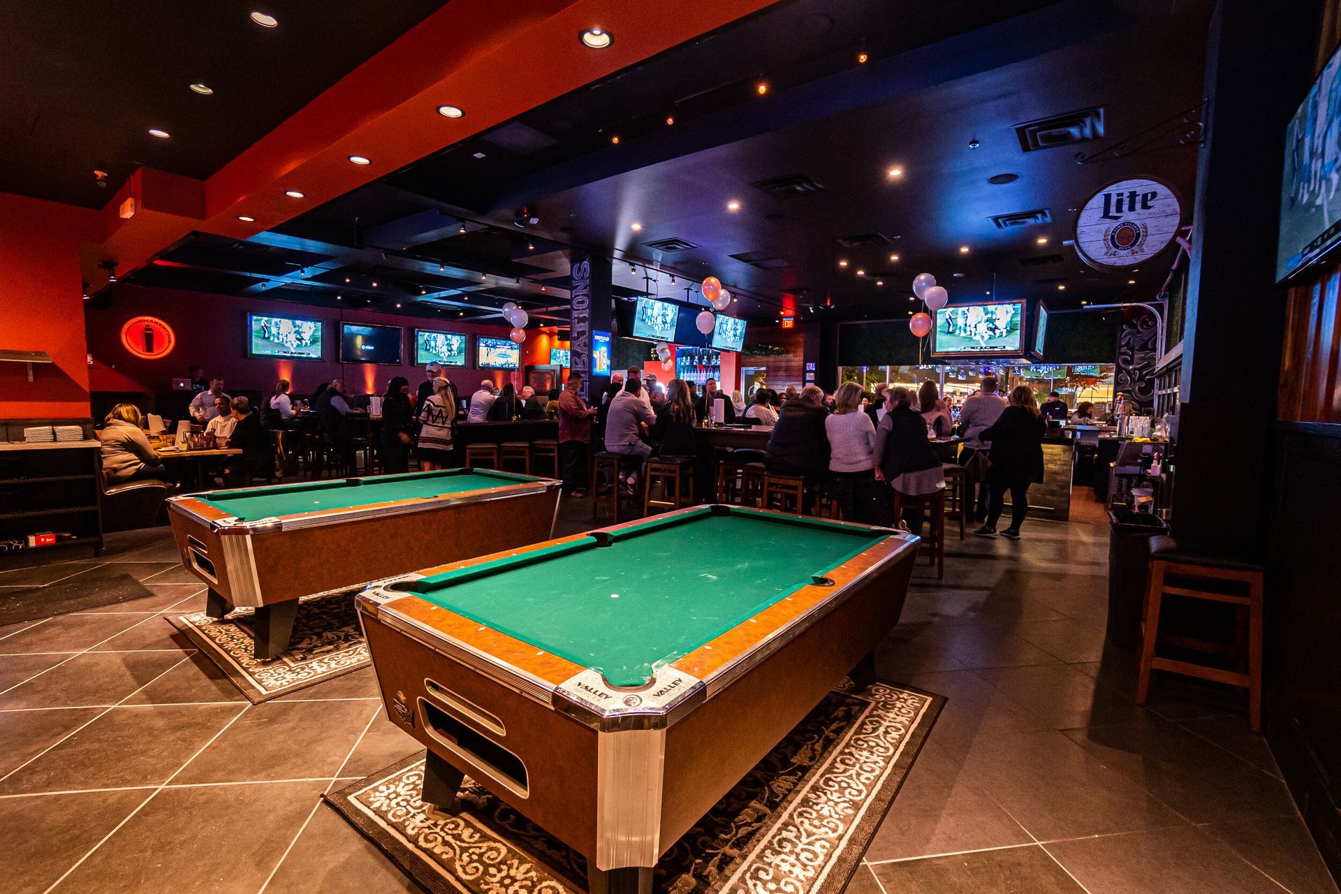 There are two pool tables in the middle of the room.