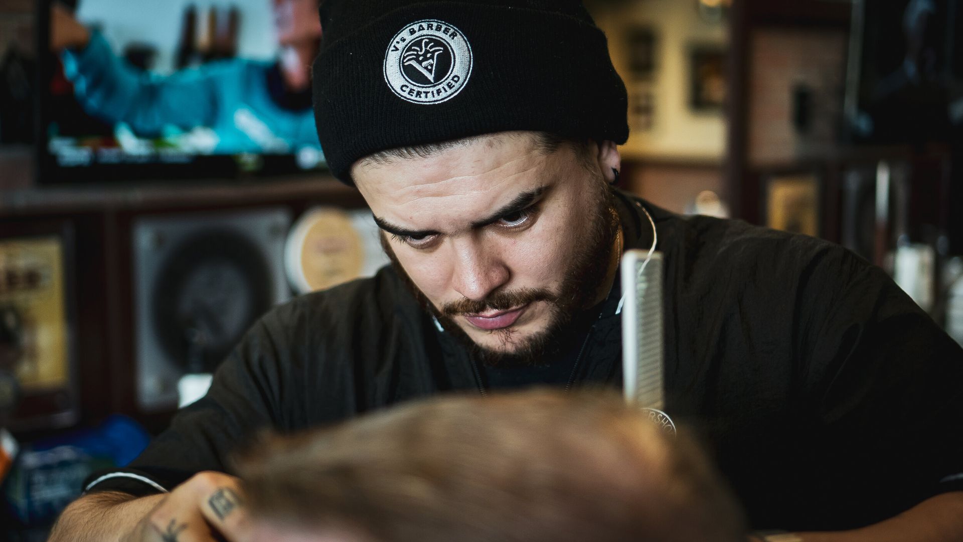A man is cutting a man 's hair in a barber shop.
