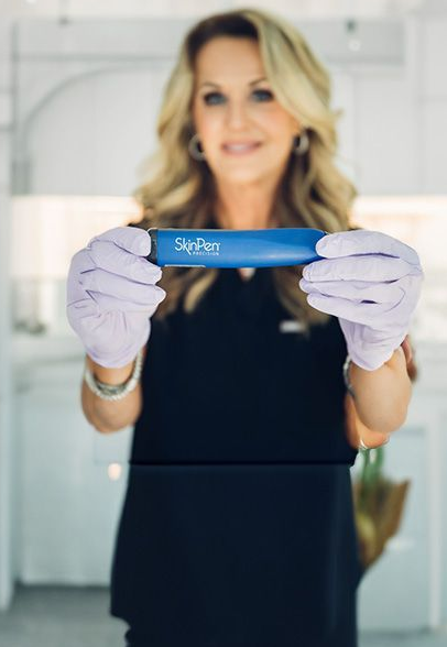 Woman in gloves holding blue SkinPen device.