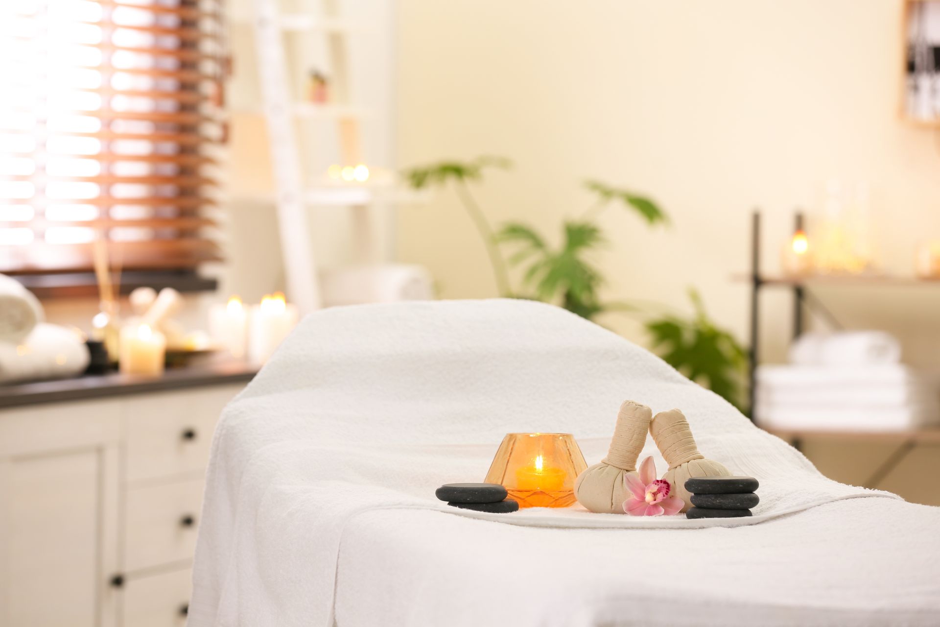 Spa setting with massage table, candles, and spa tools.