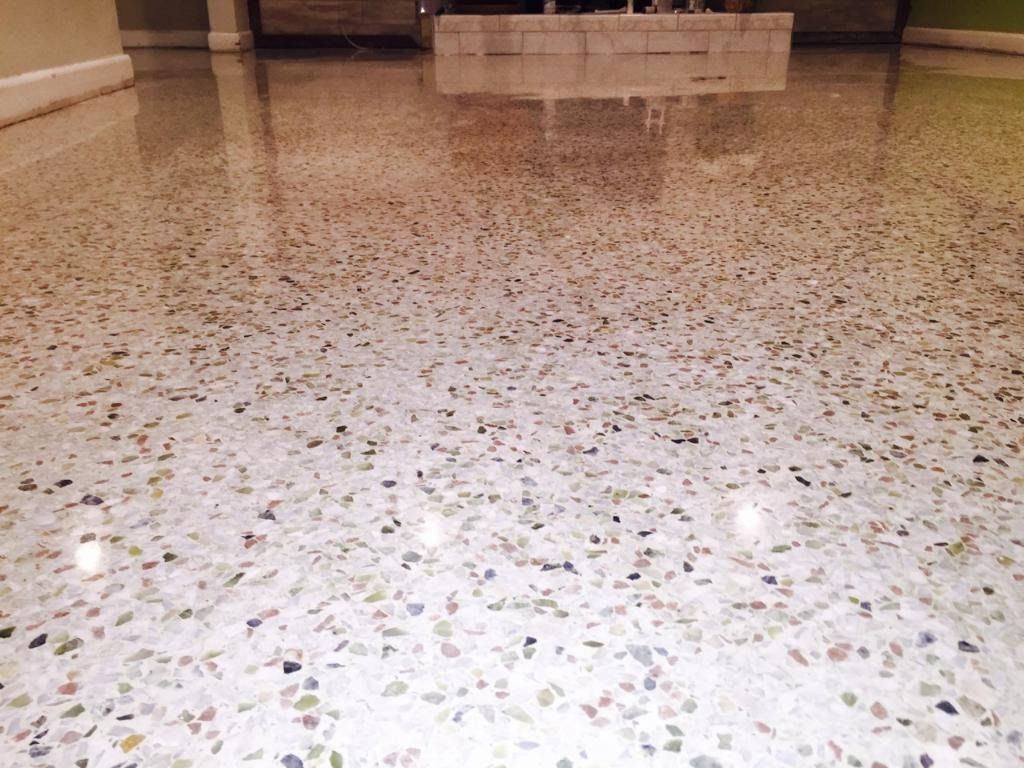 Polished white terrazzo flooring with multicolored stone flecks reflecting interior lighting.