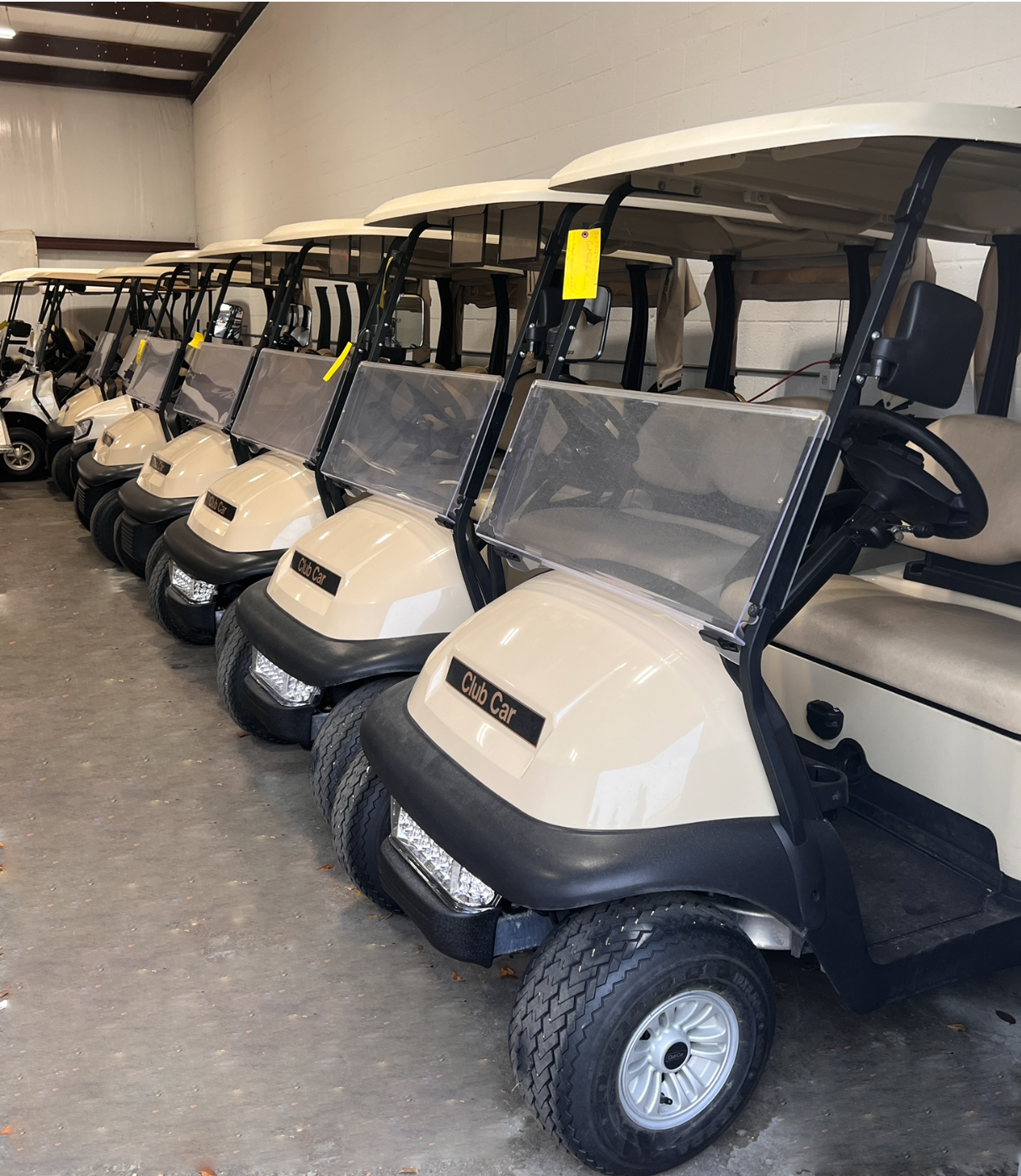 Beige Club Cars lined up  Cape Coral, FL Hole In One Golf Carts