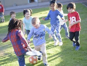 Montessori children playing together outside, learning empathy, cooperation, and friendship skills.