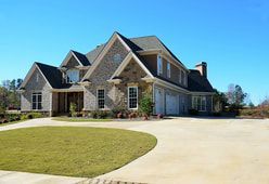 A large house with a large driveway in front of it.