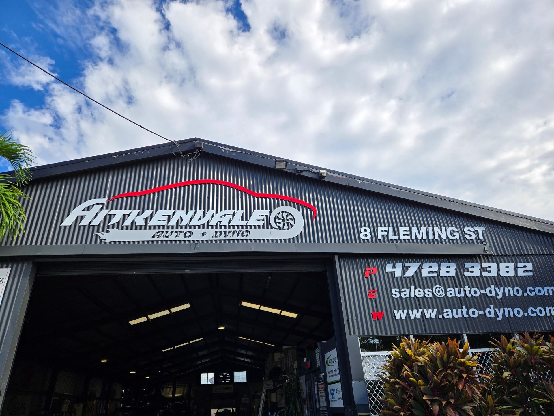 A Man is Changing a Tire on a Car in a Garage — Aitkenvale Auto & Dyno in Aitkenvale, QLD