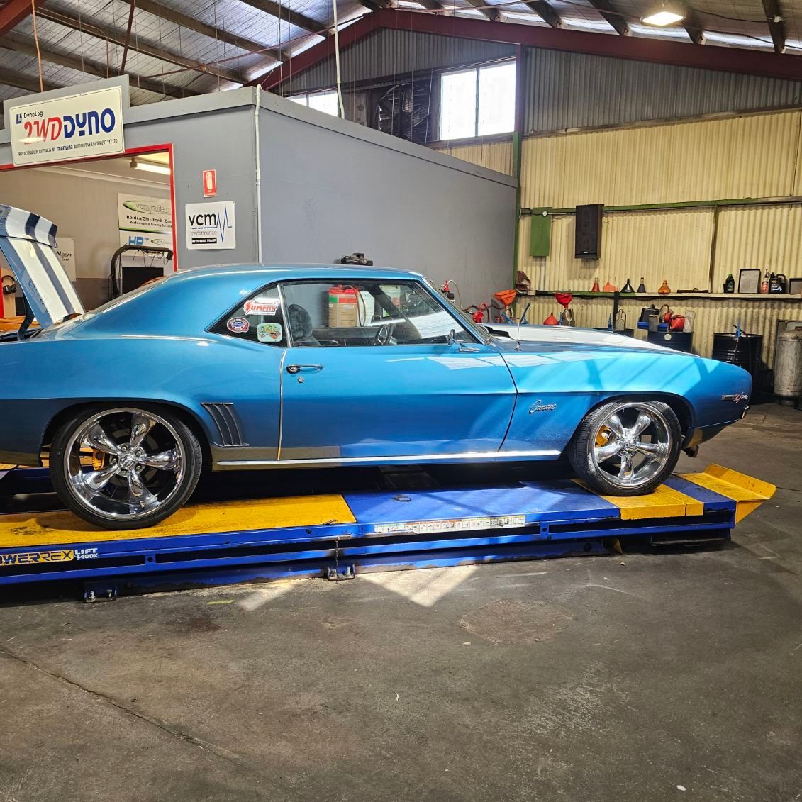 A Man is Checking the Oil Level of a Car With an Oil Dipstick — Aitkenvale Auto & Dyno in Aitkenvale, QLD
