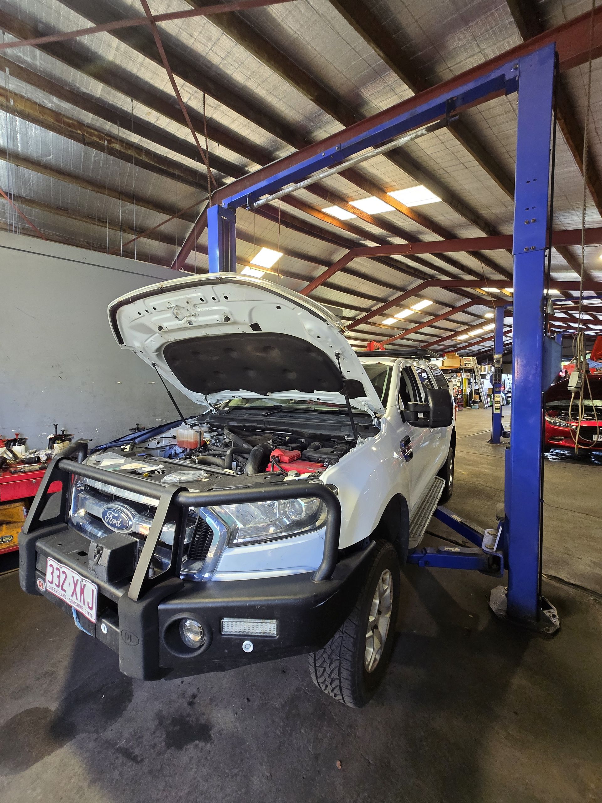 A White Truck With the Hood Open is Parked in a Garage — Aitkenvale Auto & Dyno in Aitkenvale, QLD