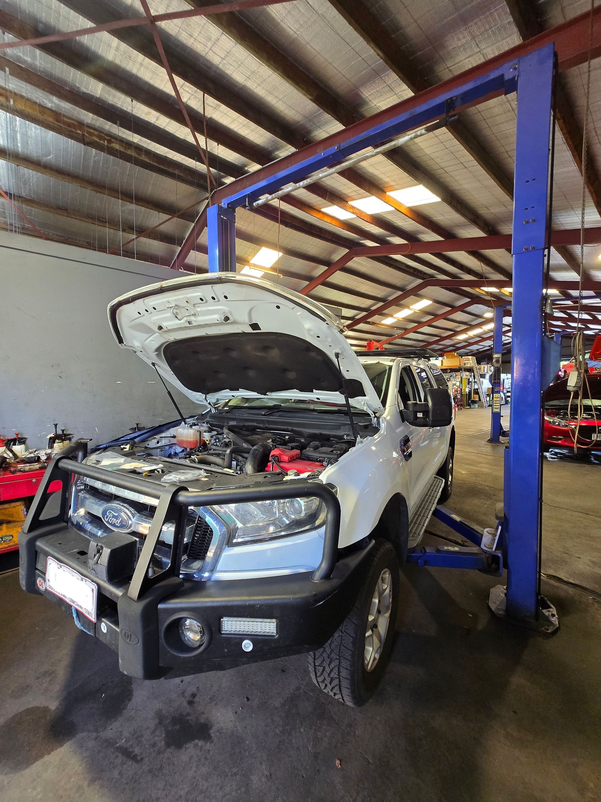 A White Car On A Hoist— Aitkenvale Auto & Dyno in Aitkenvale, QLD