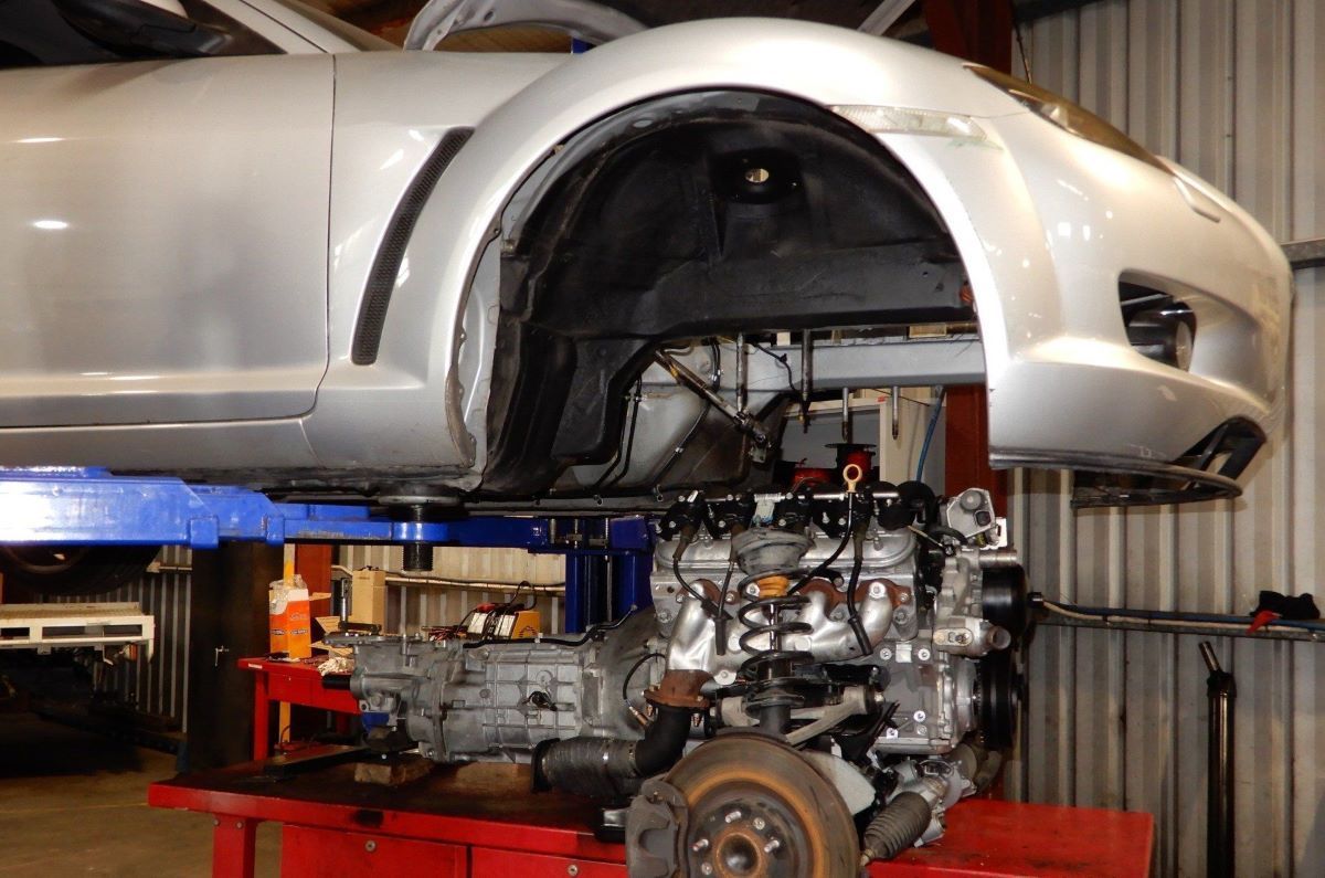 A Car With the Engine Removed is Sitting on a Lift in a Garage — Aitkenvale Auto & Dyno in Aitkenvale, QLD