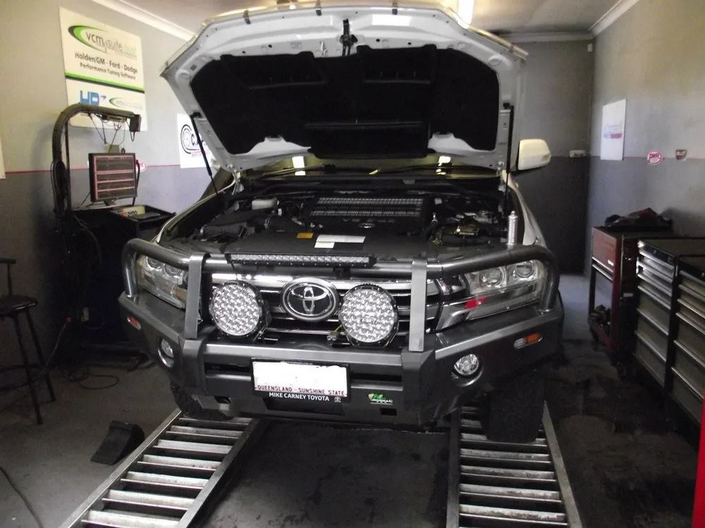 A Toyota Truck With the Hood Up is Sitting on a Ramp in a Garage — Aitkenvale Auto & Dyno in Aitkenvale, QLD