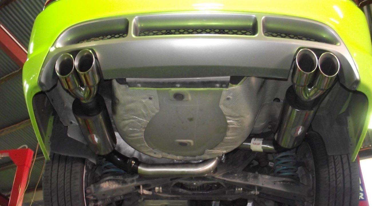 The Bottom of a Green Car With Two Exhaust Pipes — Aitkenvale Auto & Dyno in Aitkenvale, QLD
