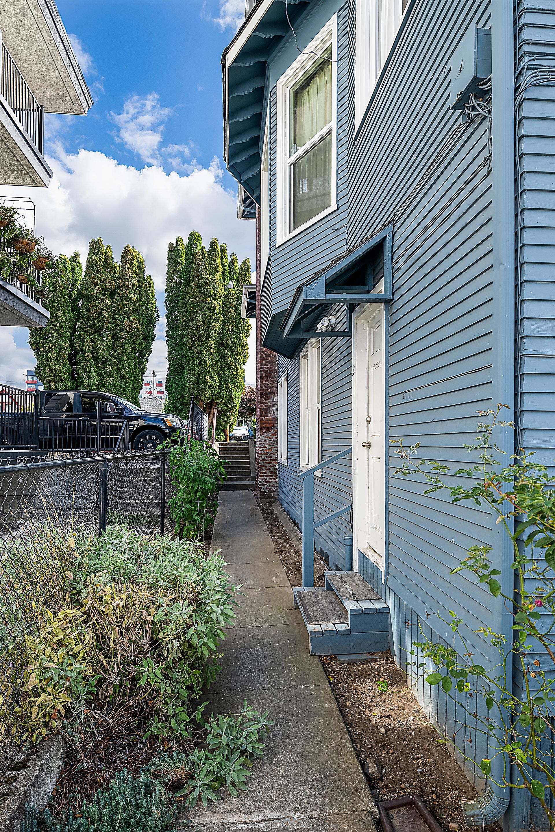 Photo showing an entrance to a suite, with the door on the side of the house