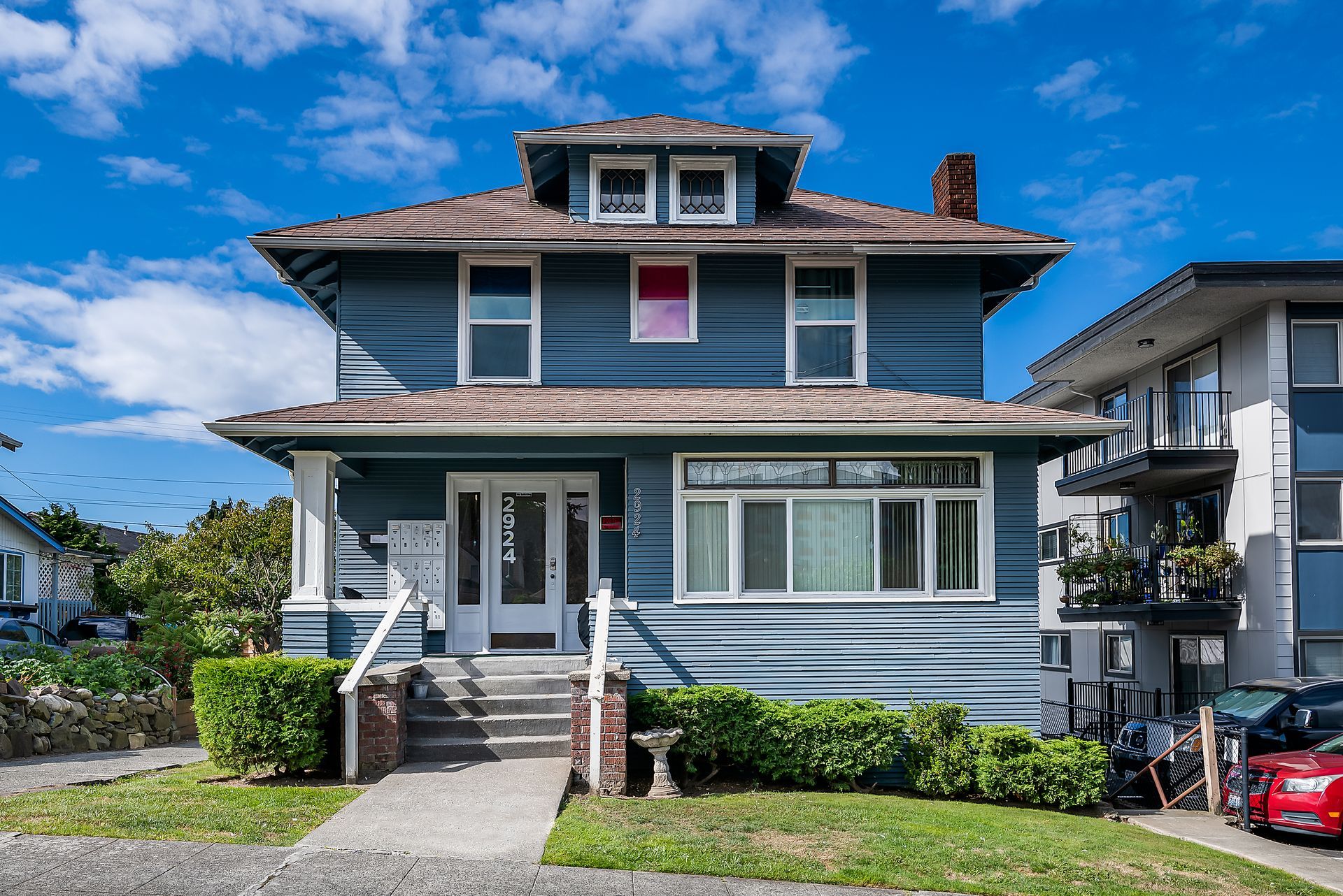 Photo of the building, showing front steps, lawn and porch