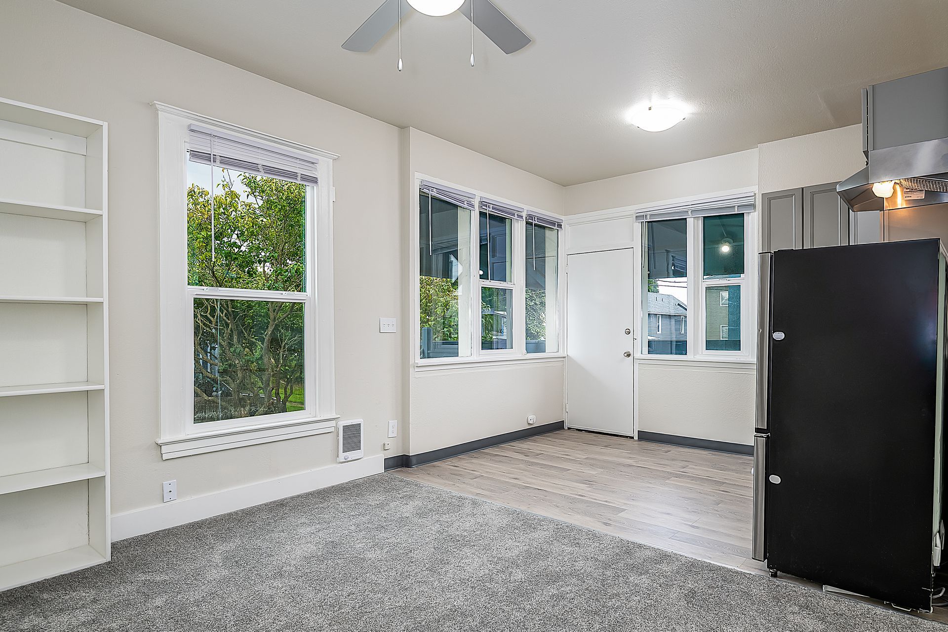 Photo showing a kitchen and living room with plenty of natural lighting