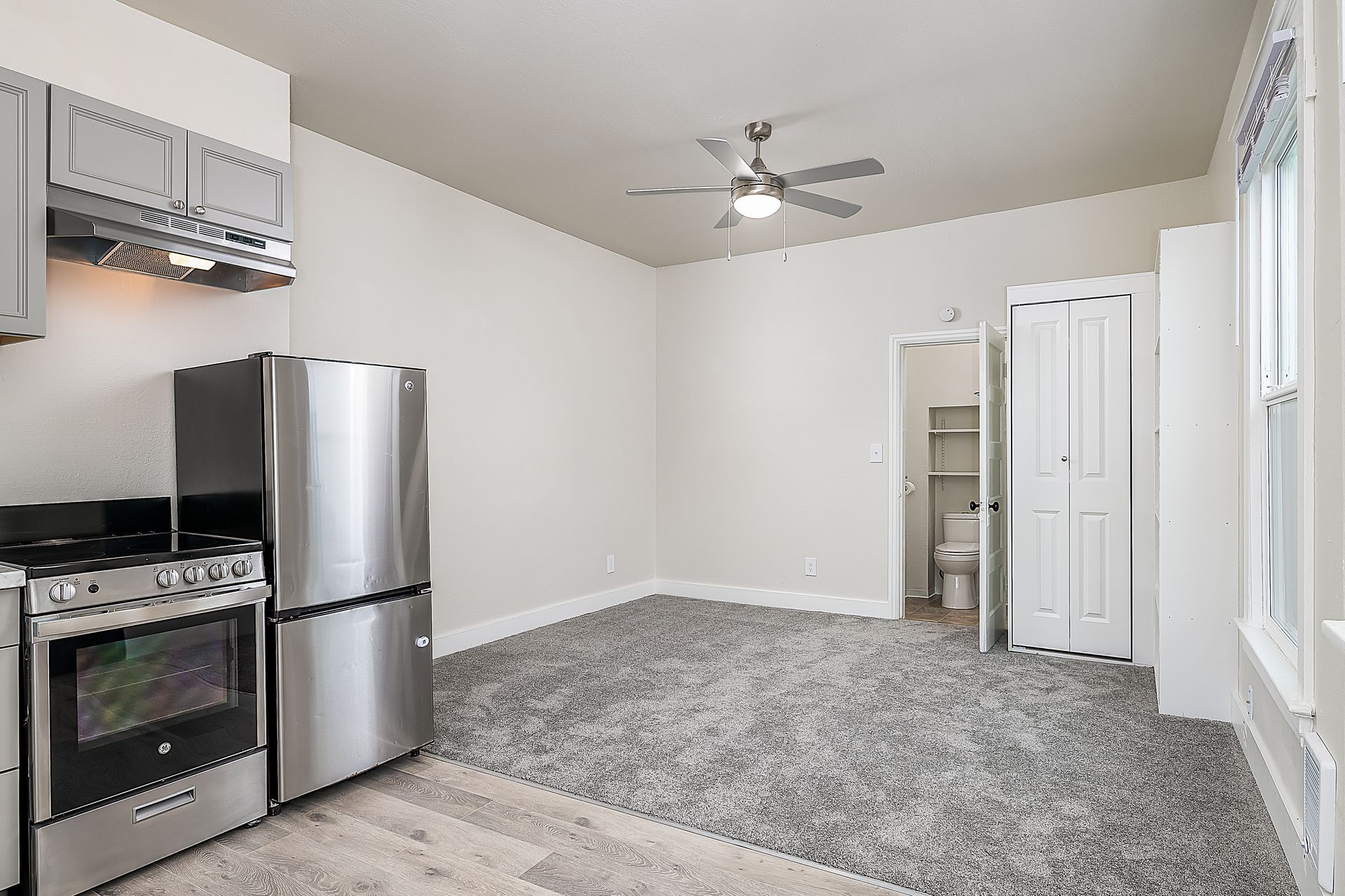 Photo of a living room, seen from the kitchen, with a bathroom in the background