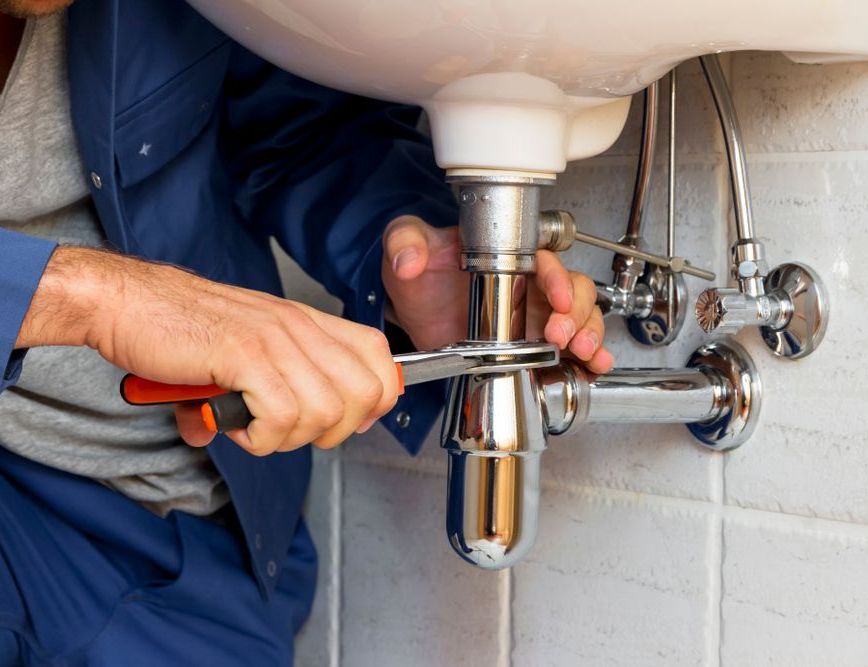 a man fixing a broken pipe