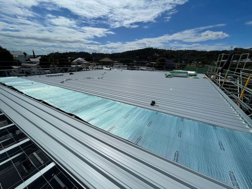 The Roof Of A Building Under Construction With A Blue Sky In The Background — Coastal Plumbing Group in Woolgoolga, NSW