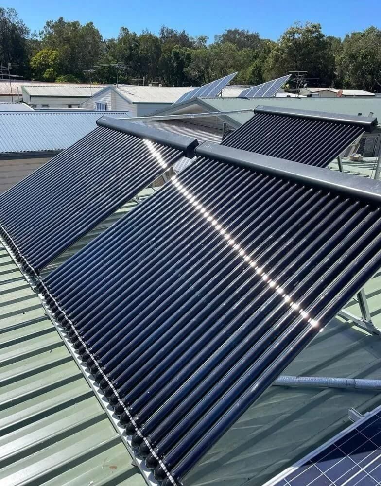 A White Water Heater Is Sitting Next To A White Tank In A Room — Coastal Plumbing Group in Woolgoolga, NSW