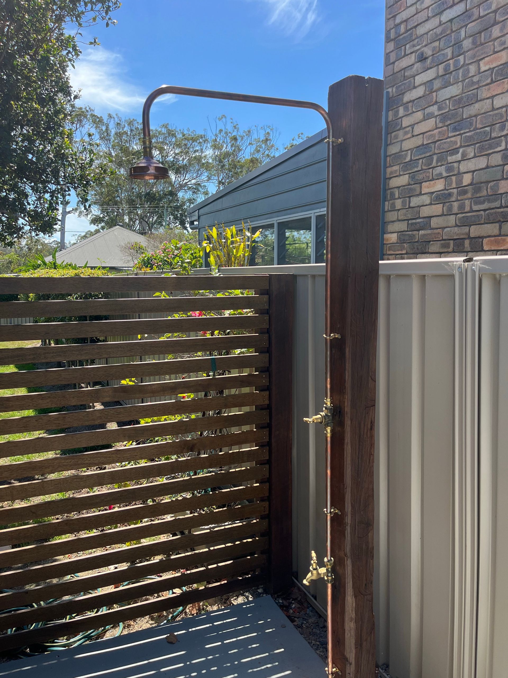 A Plumber Is Fixing A Sink In A Kitchen — Coastal Plumbing Group in Woolgoolga, NSW