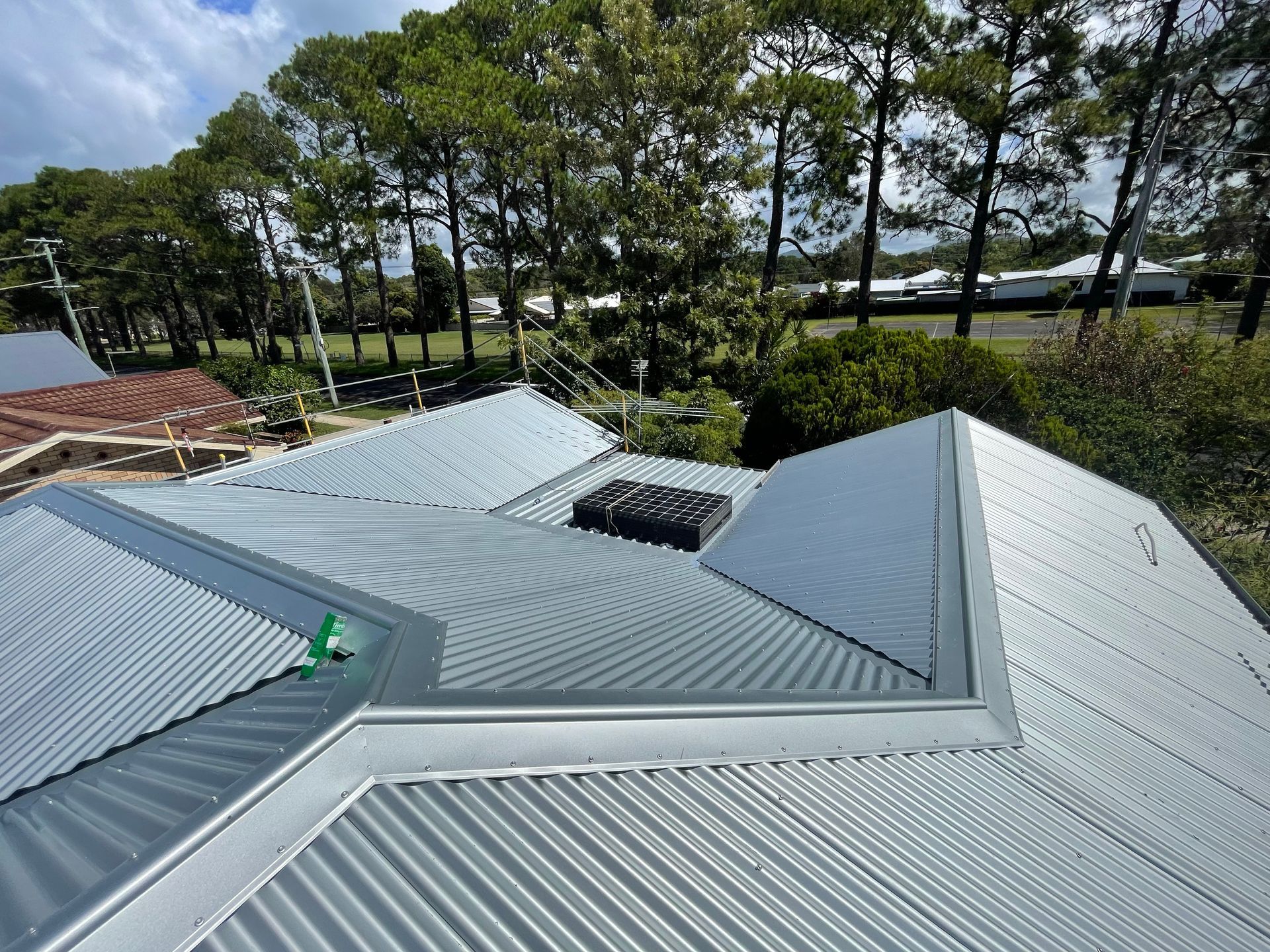 A Row Of Houses Under Construction With Scaffolding On The Roofs — Roof Repairs Coffs Harbour -Coastal Plumbing Group in Woolgoolga, NSW