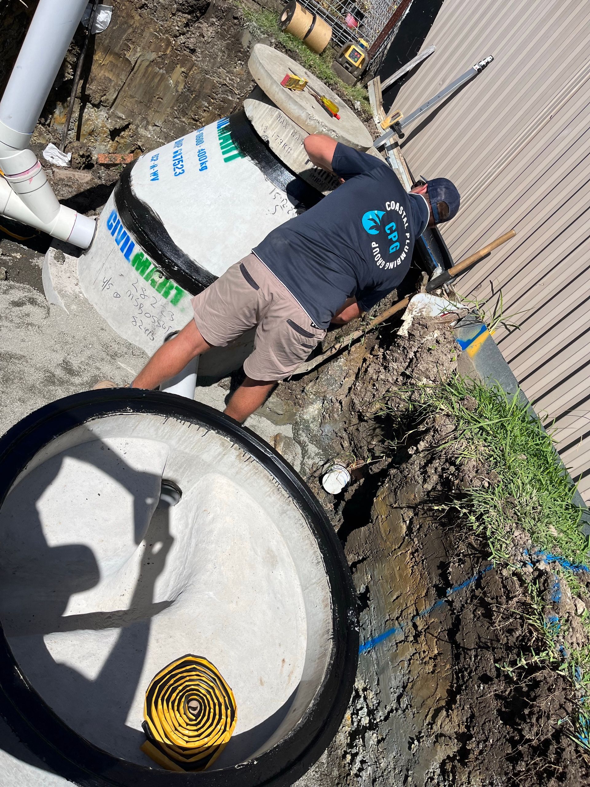 A Person Is Using A Plumbing Tool To Unblock A Sink Drain — Coastal Plumbing Group in Sawtell, NSW