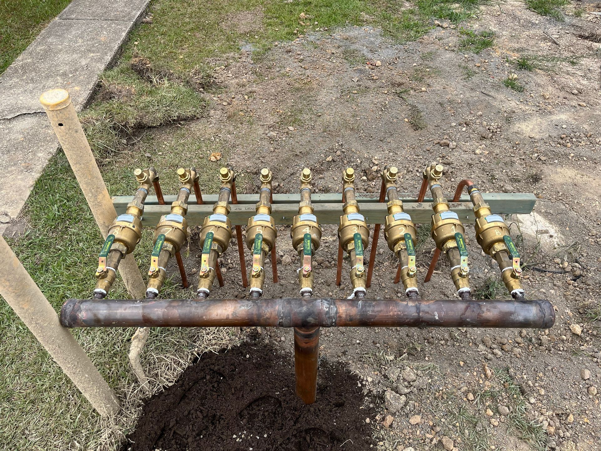 A Man Is Fixing A Pipe In A Puddle Of Water — Coastal Plumbing Group in Woolgoolga, NSW