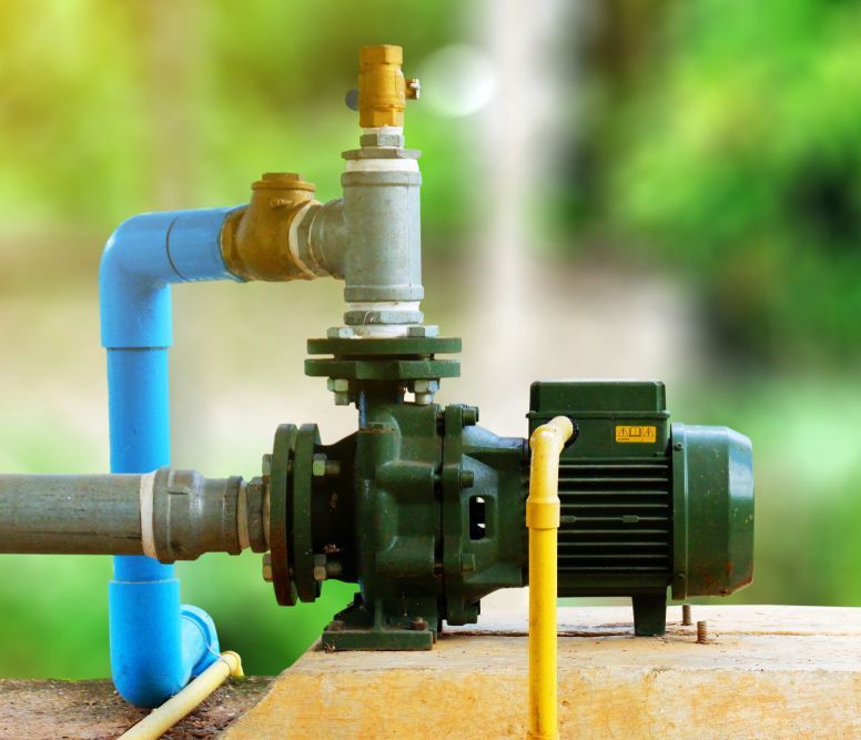 A Green Water Pump Is Attached To A Blue Pipe — Coastal Plumbing Group in Woolgoolga, NSW