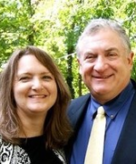 A man in a suit and tie is posing for a picture with a woman.