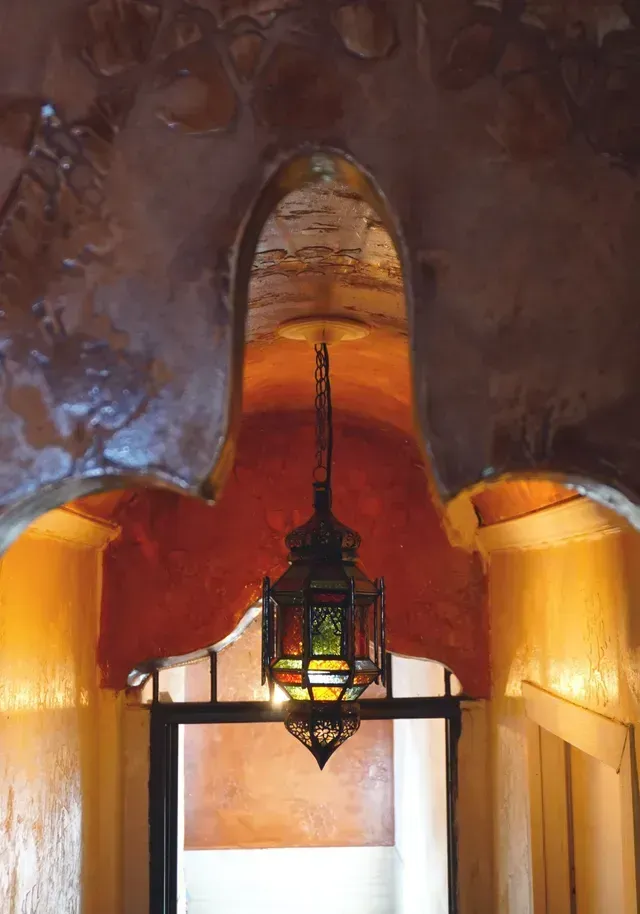 Un corridoio con una lanterna appesa al soffitto