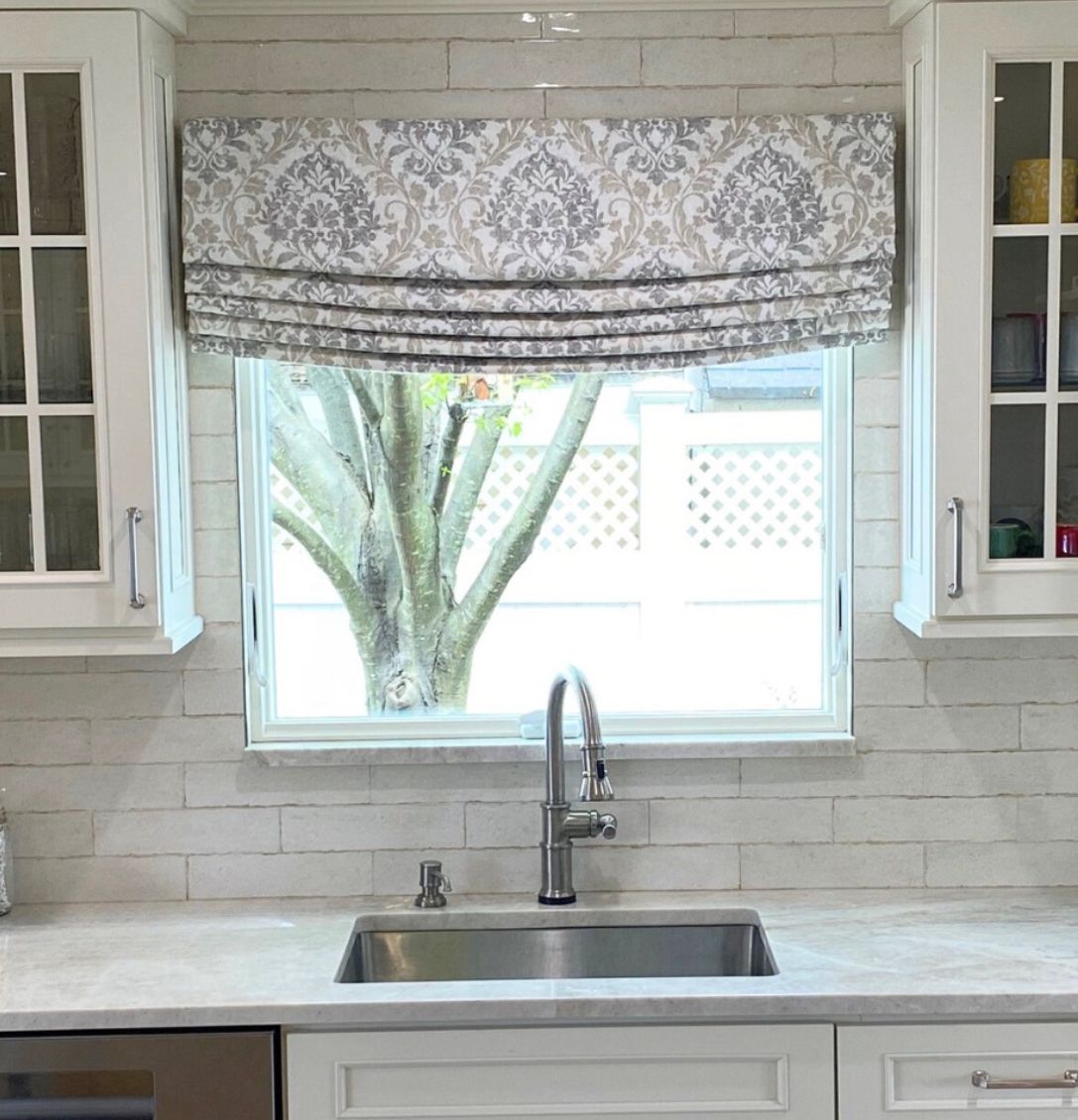 Designer material relaxed style roman shade in kitchen.