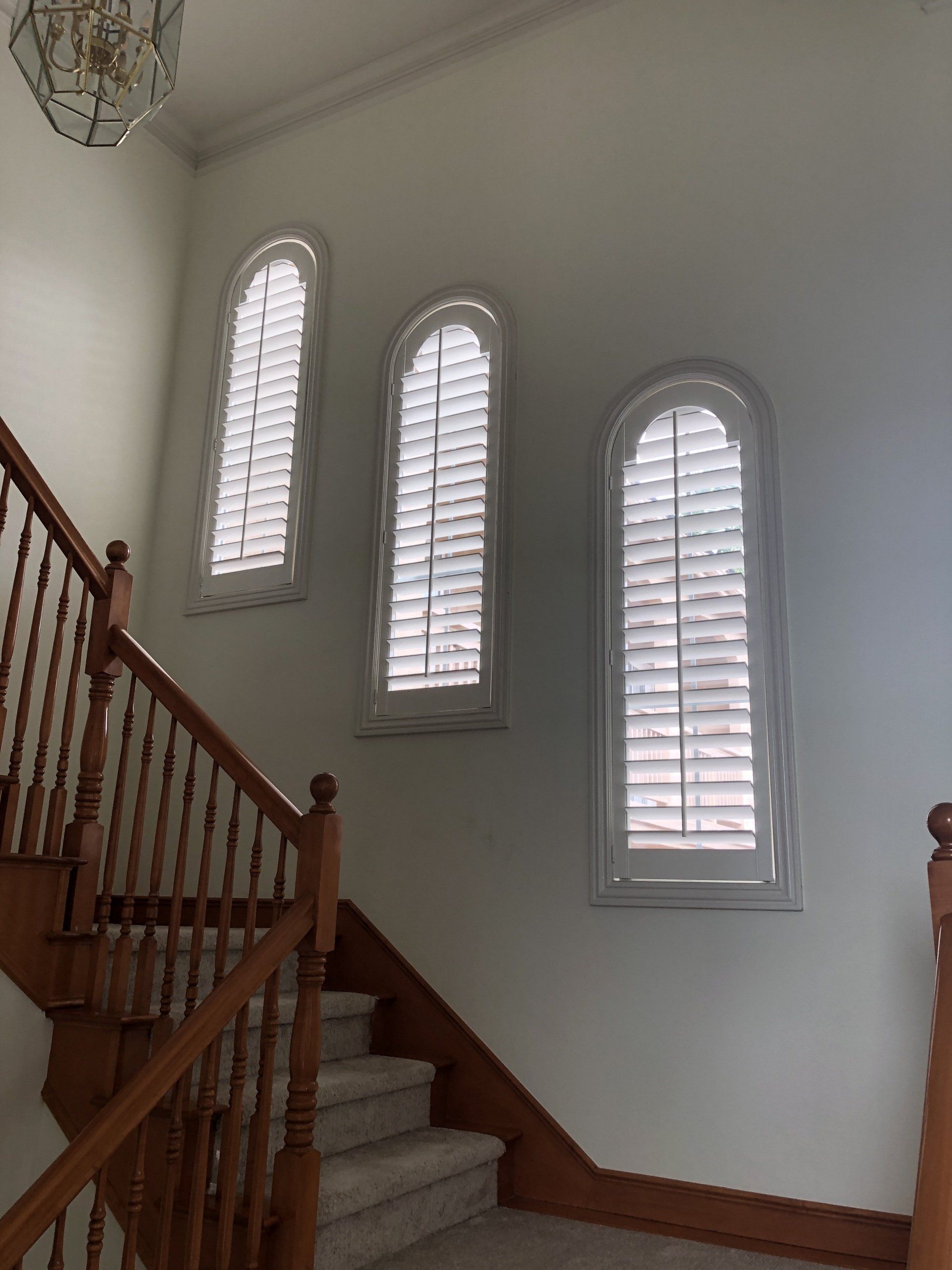 Arched interior Window Shutters in Carlsbad, CA home stairway.