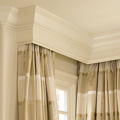 ivory wood cornice over draperies in dining room by window spaces