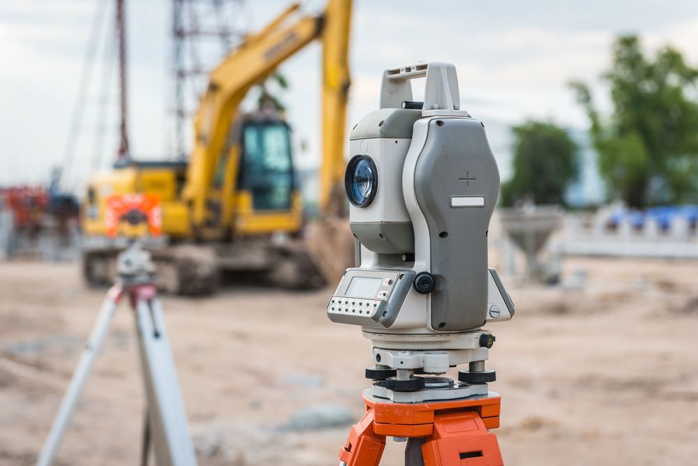 A Theodolite Is Sitting On A Tripod On A Construction Site  — CalCo Surveyors Pty Ltd in Gloucester, NSW