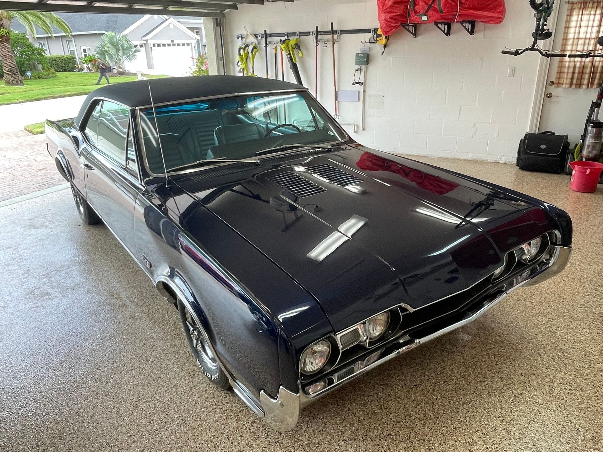 A dark blue classic Mercury Cougar parked inside a clean residential garage.