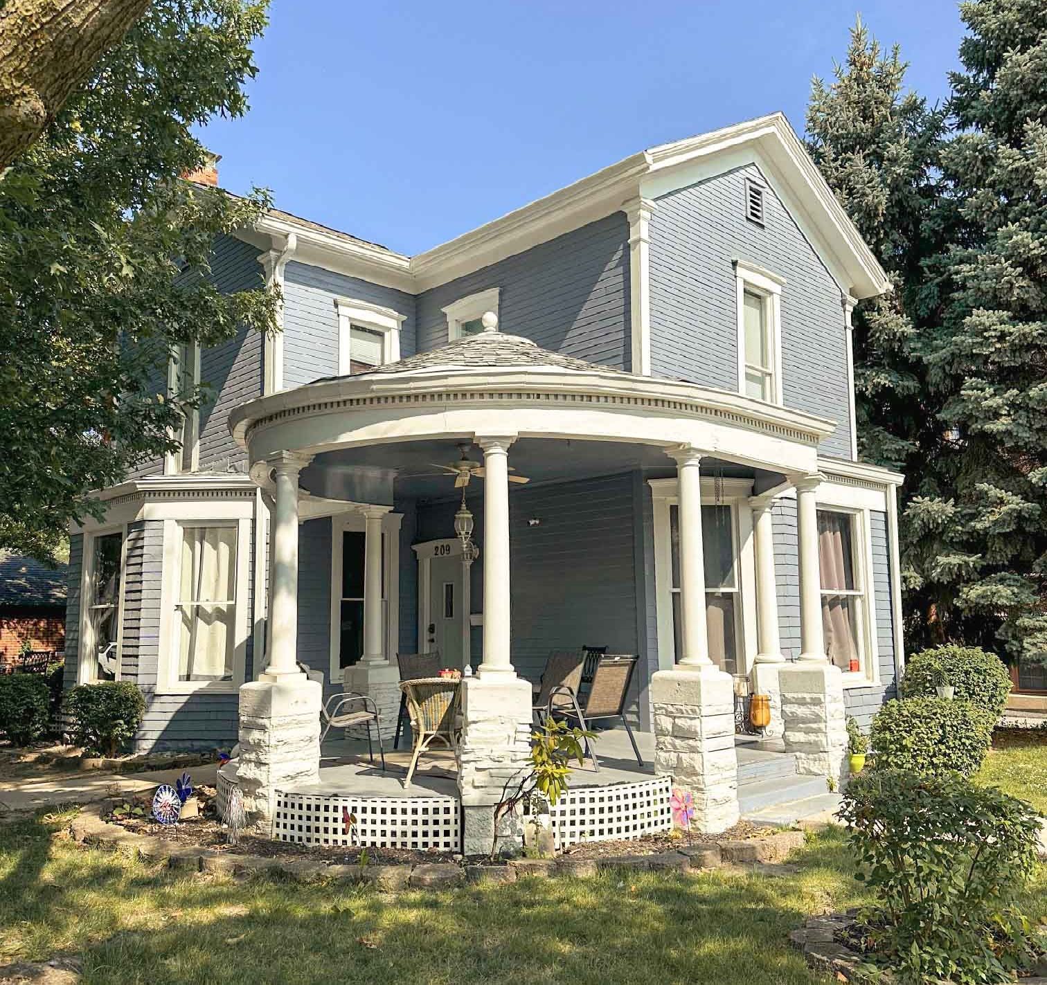 A large blue house with a porch and columns