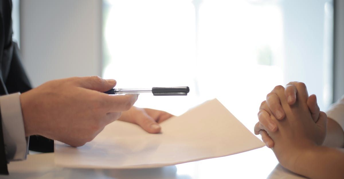 A man is holding a pen over a piece of paper.