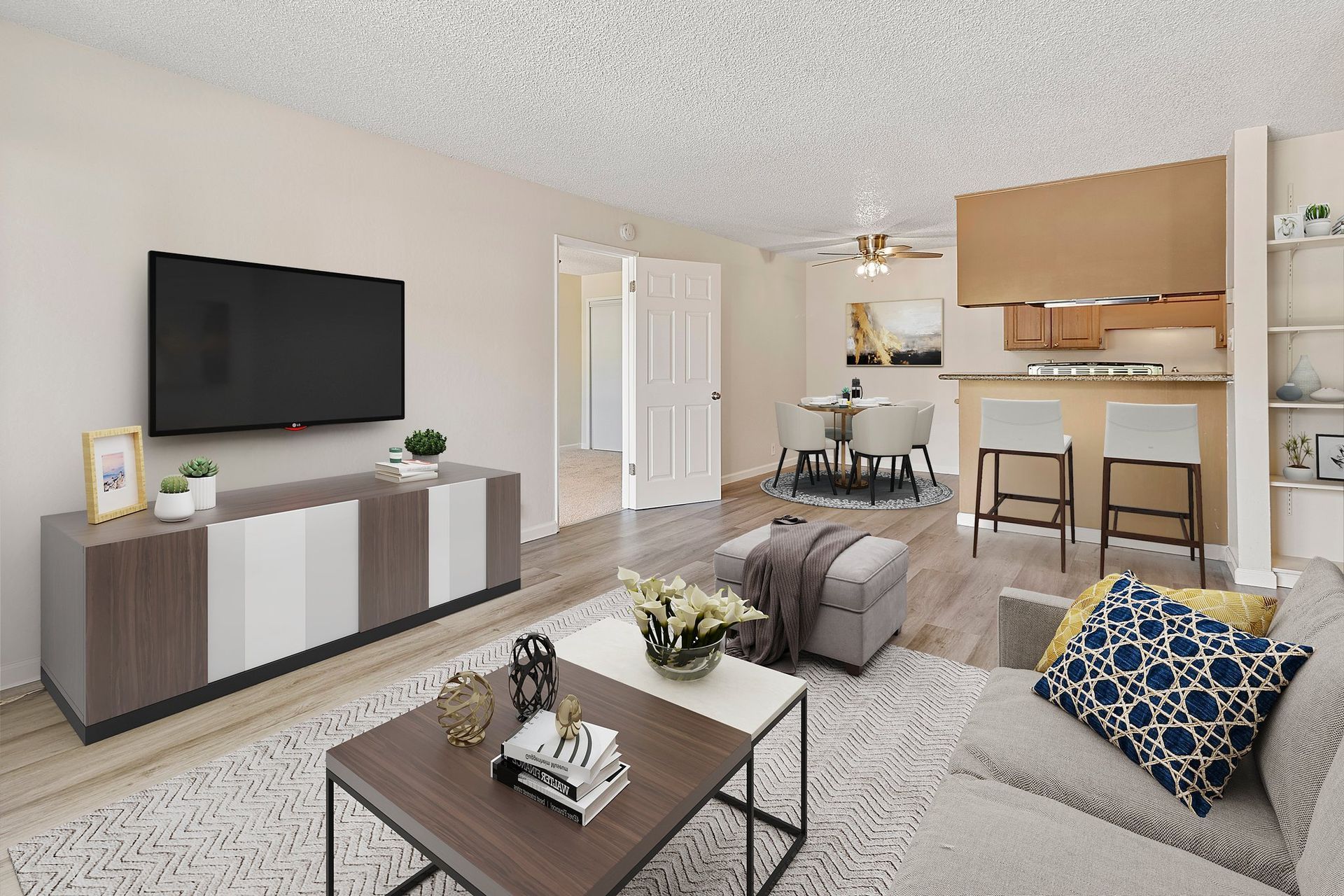 A galley-style kitchen with light wood cabinets, granite countertops, stainless steel appliances, and wood-look flooring at Parkview Apartments.