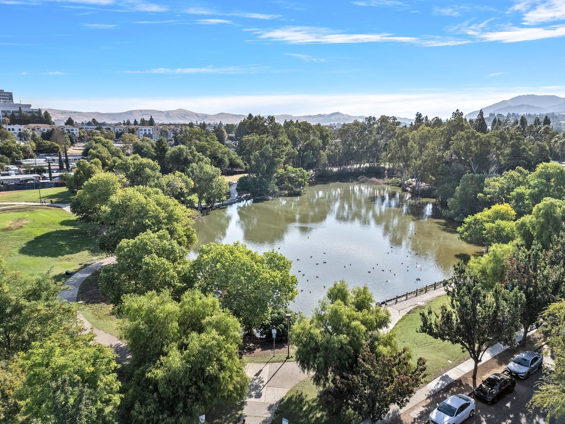 A multi-story building courtyard with a central three-tiered fountain surrounded by wooden fencing and greenery at Parkview Apartments.