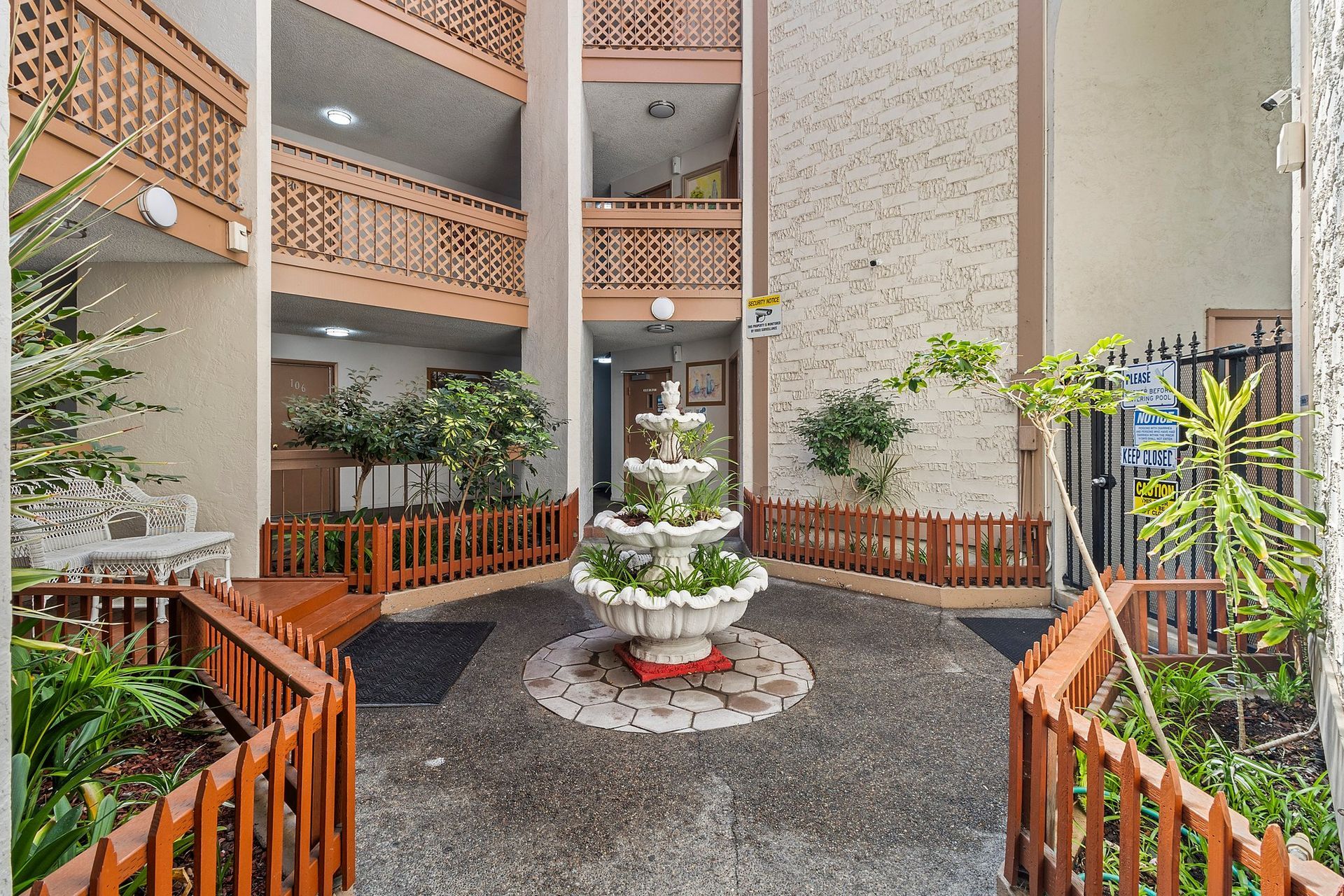 A tall atrium with a large octagonal skylight, beige textured walls, and multi-level wooden balconies at Parkview Apartments.