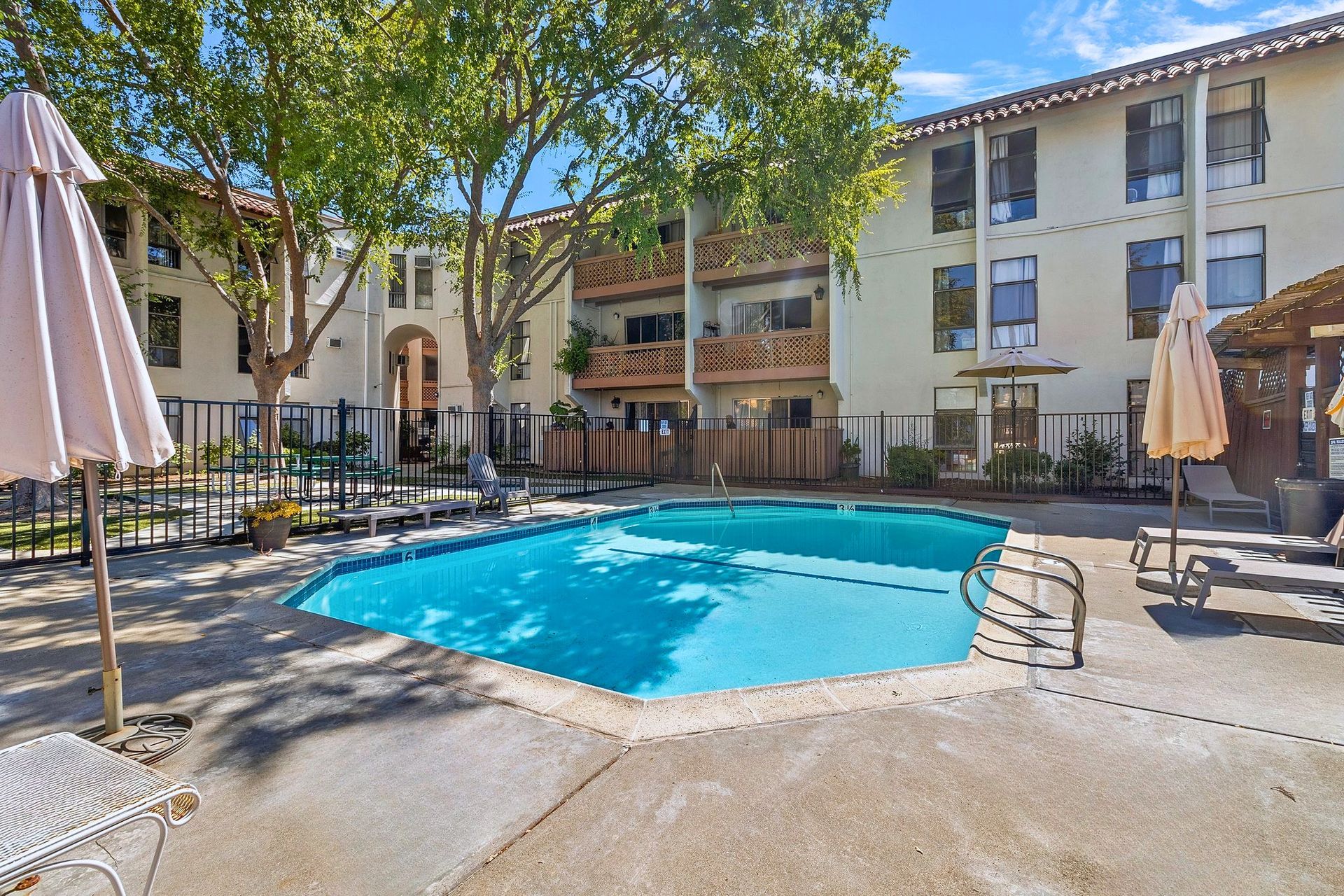 A bathroom with a white bathtub, tiled shower walls, chrome fixtures, and glass sliding doors next to a toilet at Parkview Apartments.