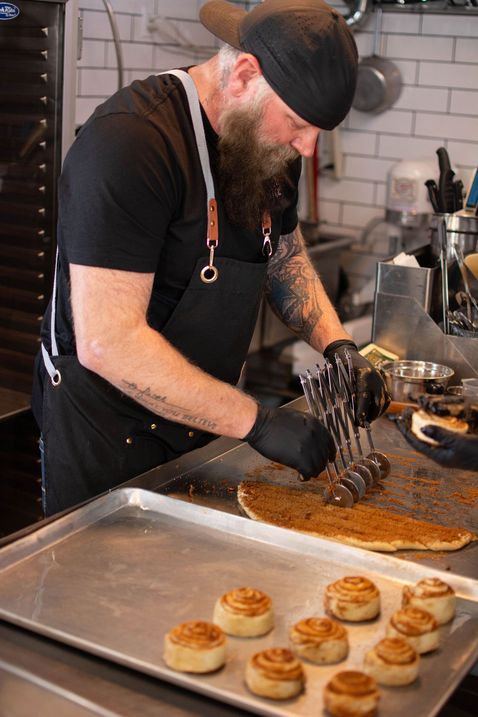 Chef adding seasoning to pastry, kitchen setting.