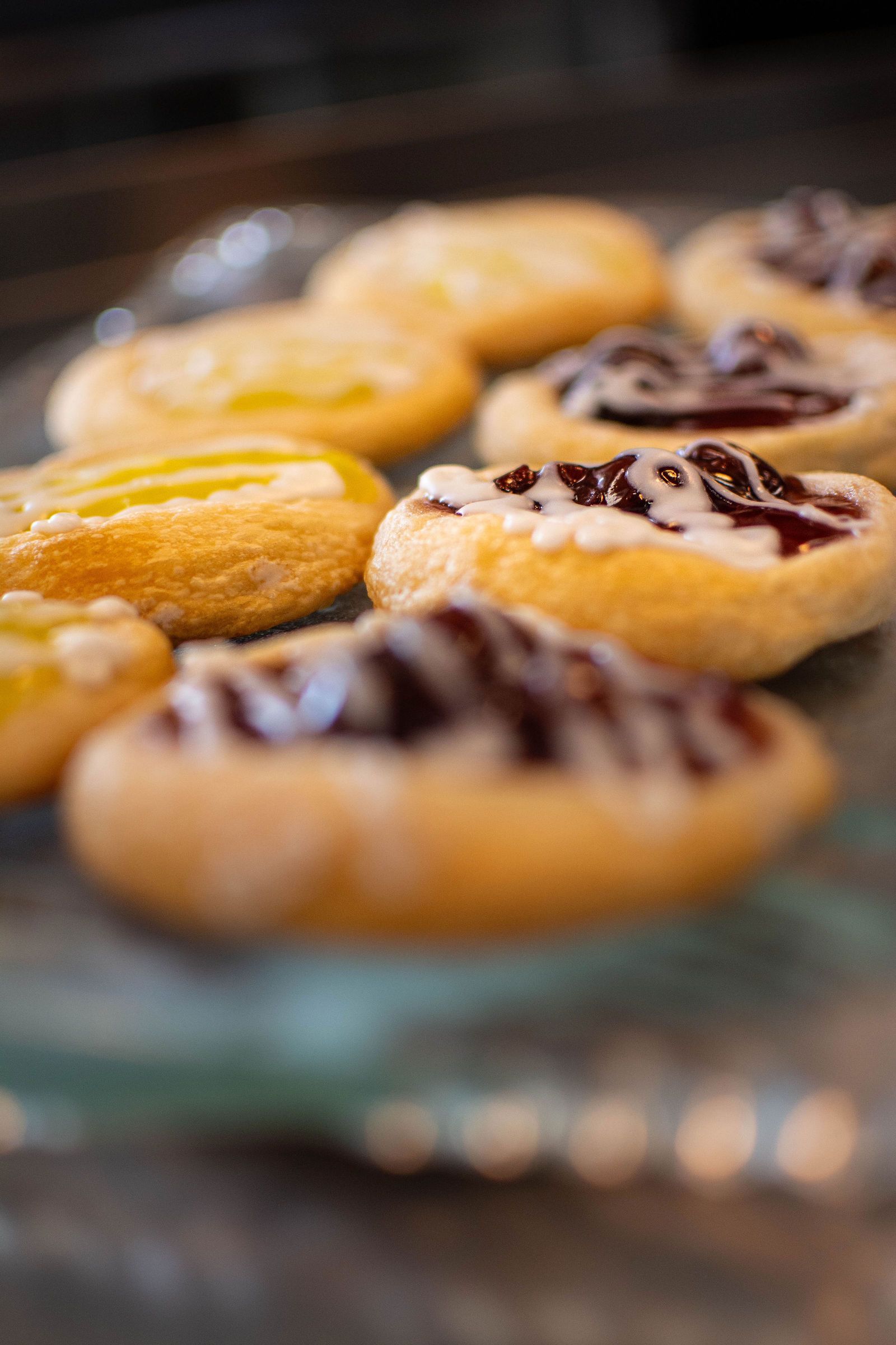 Cookies with lemon and berry toppings on a glass plate.