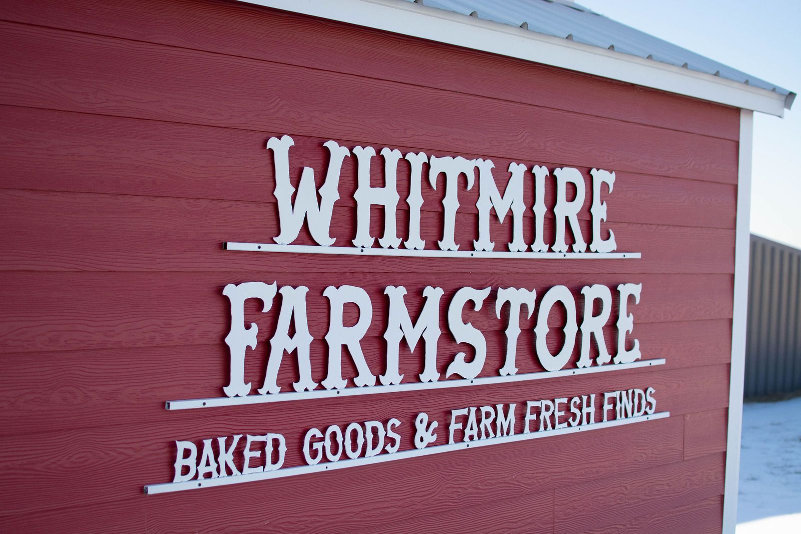Red farm store sign with white lettering: 