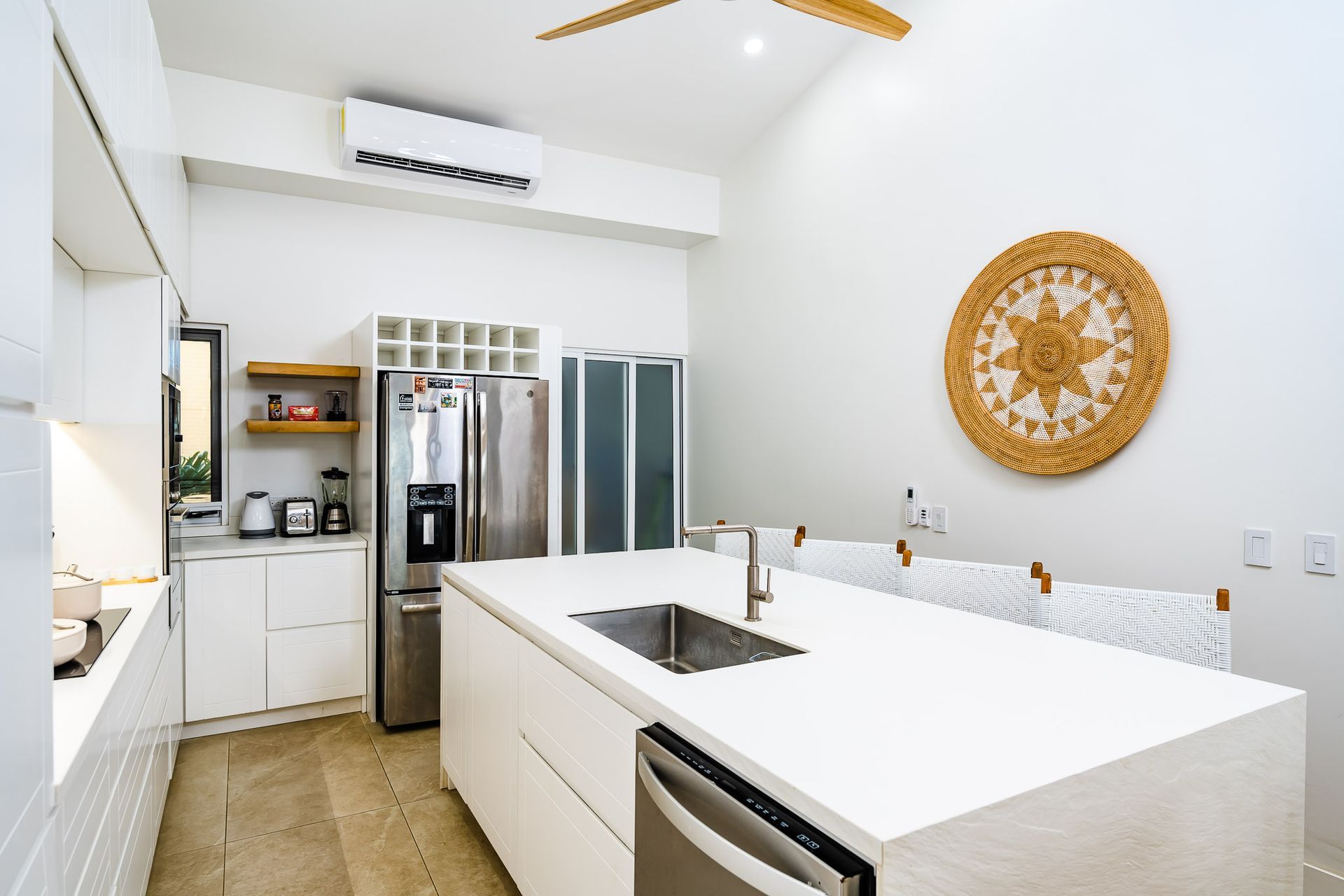 A kitchen with white cabinets , stainless steel appliances and a large island.