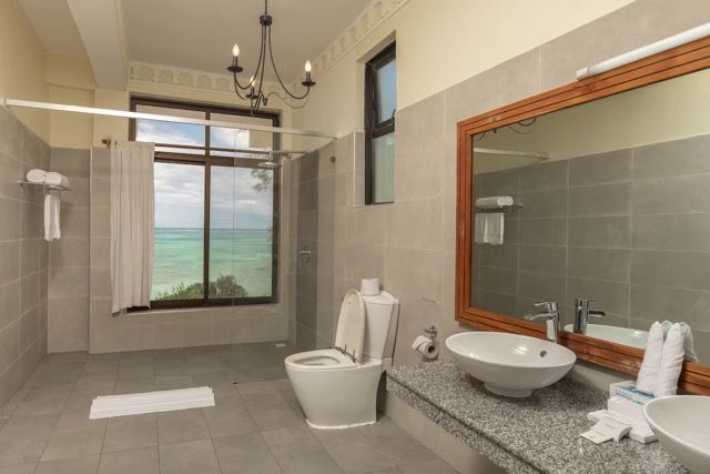 A bathroom with a toilet , sink and mirror.