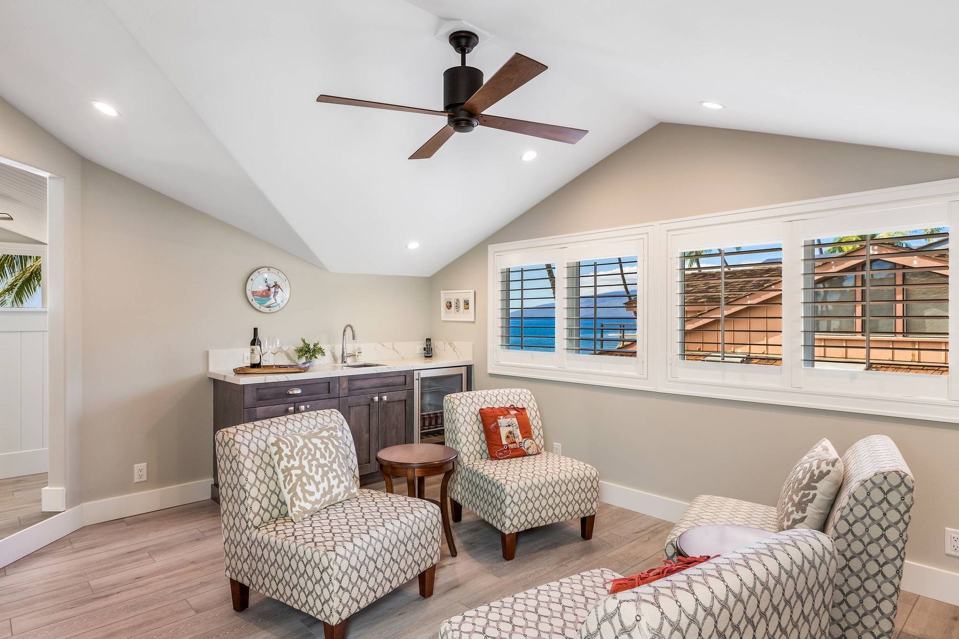 A living room with two chairs and a ceiling fan.