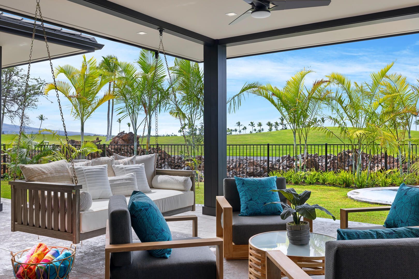 A patio with a couch , chairs , a table and a ceiling fan.